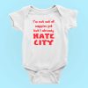 Image Alt Text Generator said: White baby onesie displayed on a light blue background, featuring bold red text that reads, "I'm not out of nappies yet but I already HATE CITY." The humorous football-themed design targets fans of rival teams opposed to Manchester City FC, making this item ideal for sports baby clothes, soccer rivalry merchandise, and gift ideas for football fan parents. Optimized for keywords like “anti-Man City baby onesie,” “funny football baby bodysuit,” and “soccer fan infant apparel.”