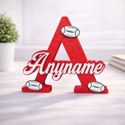 Name Letter with Rugby Balls Personalised nursery letter name sign Any name on Red initial A with rugby decorations, freestanding kids room décor displayed on nursery shelf with teddy bear and baby items. Available in multiple colour and adornment options.