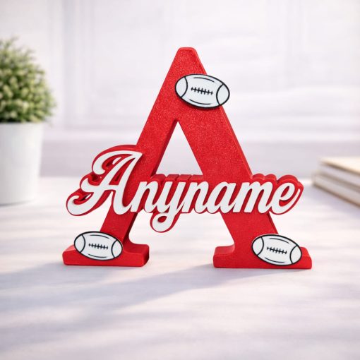 Name Letter with Rugby Balls Personalised nursery letter name sign Any name on Red initial A with rugby decorations, freestanding kids room décor displayed on nursery shelf with teddy bear and baby items. Available in multiple colour and adornment options.