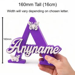 Personalised nursery letter name sign, freestanding kids room décor displayed on nursery shelf with teddy bear and baby items. Available in multiple colour and adornment options.